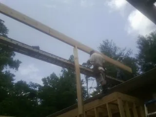 Carpenter setting a ridge beam over a new addition frame — Ice Dam Removal by Roofing Brothers in Asheville