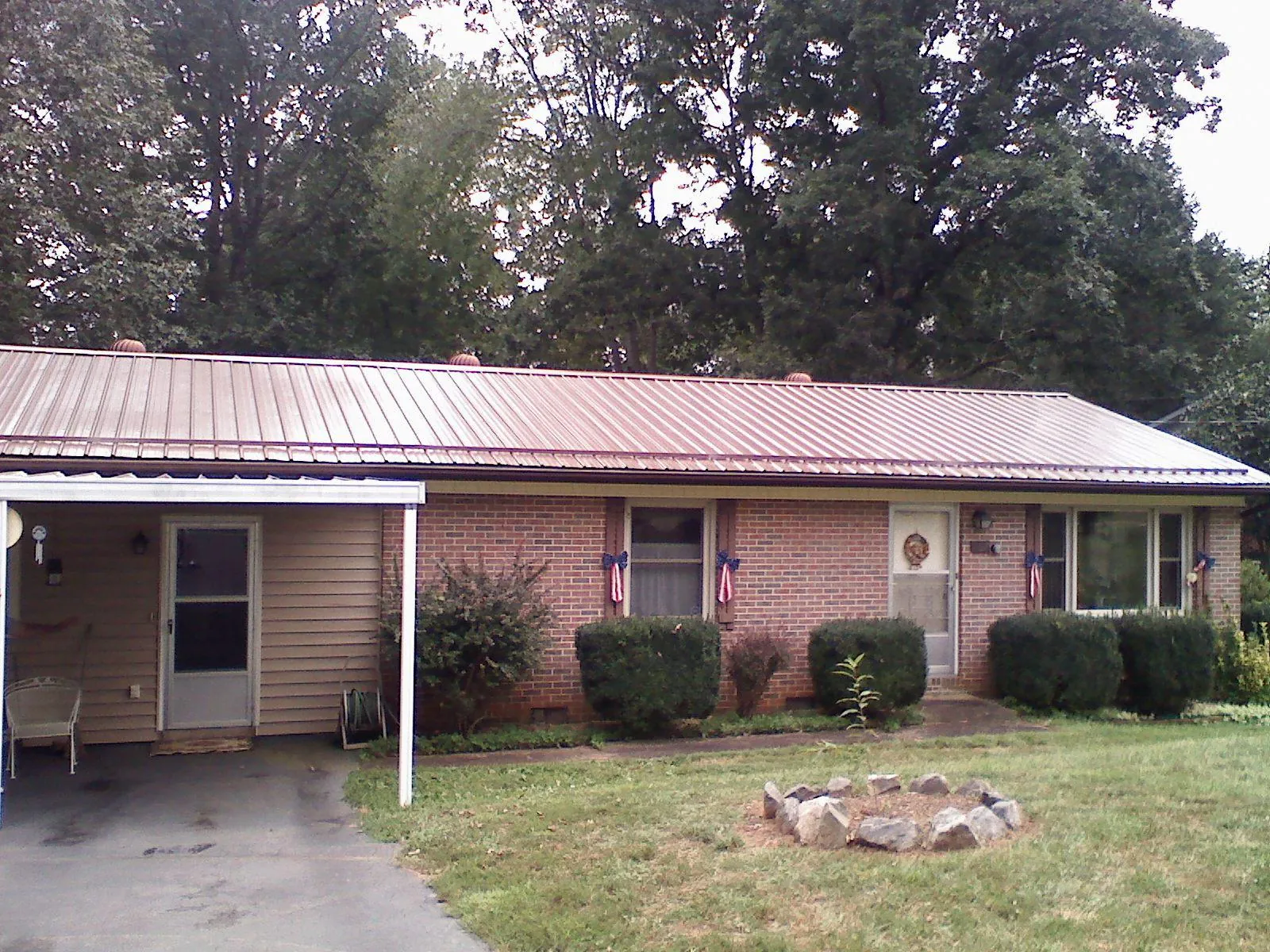 Bronze metal roof and carport on a brick ranch home — Roof Repair work by our crew in Asheville